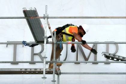 Workers remove Donald Trump’s name from the Kennedy Center building after a federal court ruling